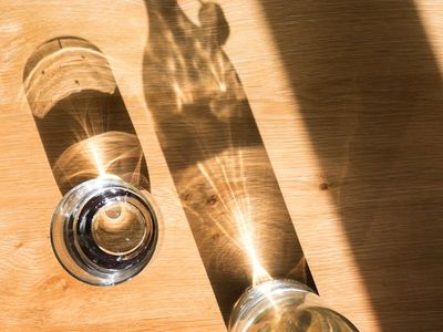 Glass water bottle on a table with morning light.
