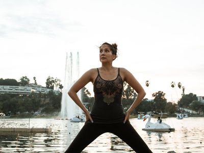 Person doing stretching exercises in a park during sunrise.